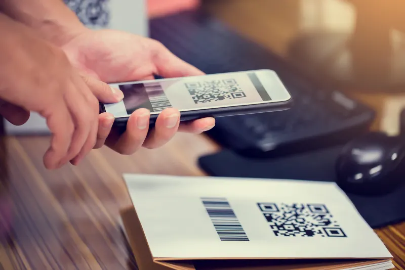 Mão segurando o celular para ler um QR Code